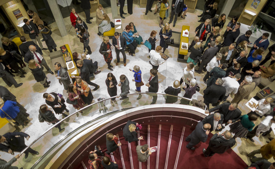 Audience members gathered in an upper level in Theatre Royal Glasgow, looking down the main spiral staircase